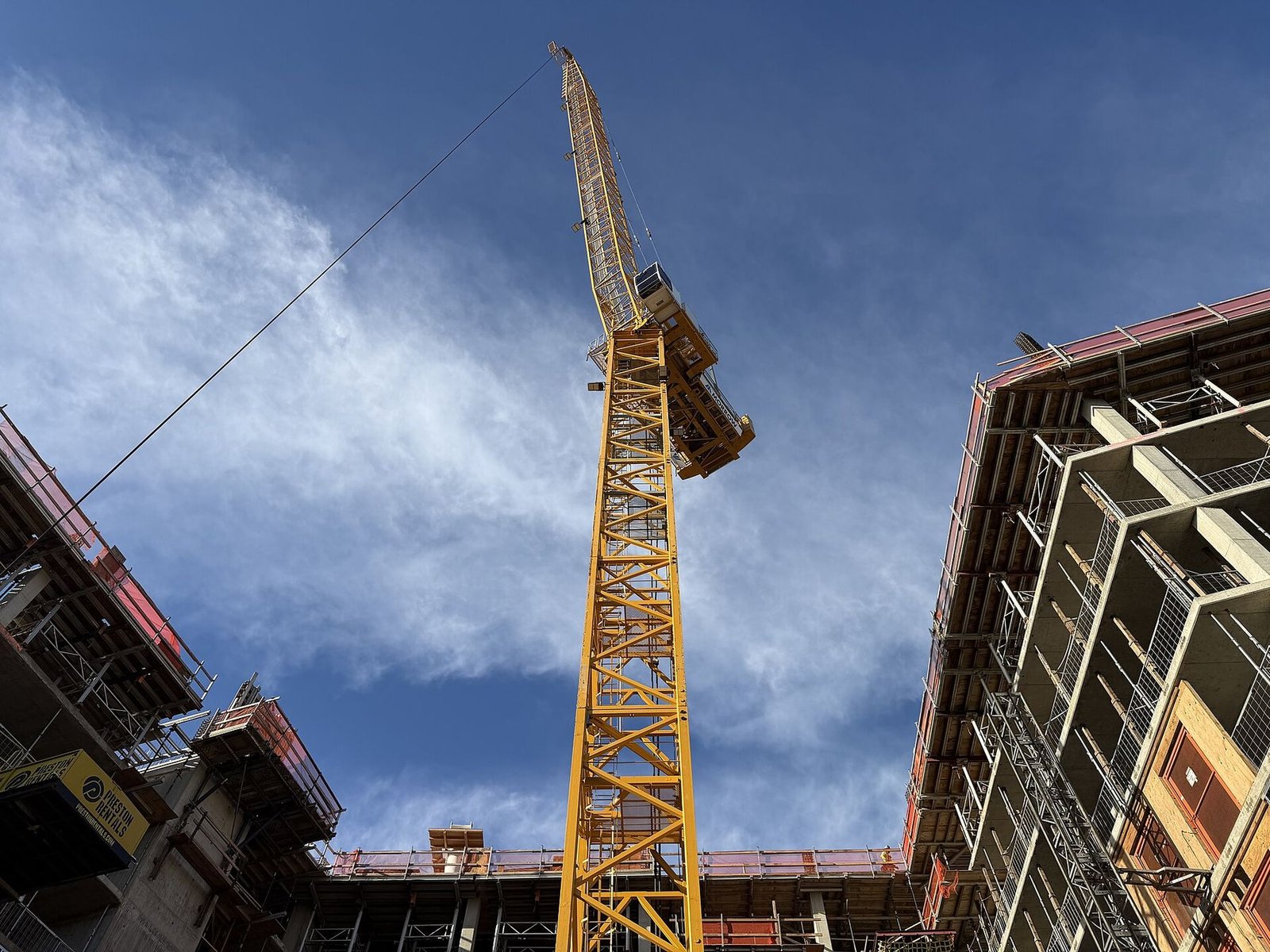 Guindaste de torre entre a estrutura de concreto e aço de um edifício em construção